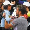  ?? Anne-Christine Poujoulat / Getty Images ?? Stan Wawrinka holds a young fan in his arms as he signs autographs after his win.