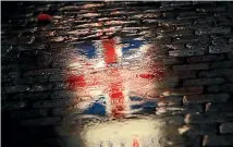 ?? AP ?? The Union flag is reflected in a puddle during an event called "Brussels calling" to celebrate the friendship between Belgium and Britain at the Grand Place in Brussels.