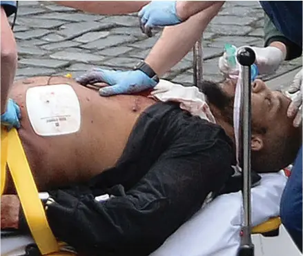  ?? (Photo by Stefan Rousseau/PA via AP). ?? In this March 22, 2017 file photo, the attacker Khalid Masood is treated by emergency services outside the Houses of Parliament London. British Police named on Thursday March 23, 2017, Khalid Masood as The Houses of Parliament attacker.