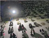  ?? RAMON ESPINOSA/AP ?? A child shines a light on hundreds of shoes at a memorial June 1 in front of the Capitol in San Juan for those killed by Hurricane Maria.