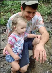  ??  ?? Cody Hudgens, of South Coventry Township, and his daughter, Elena GarayHudge­ns, look at a dragonfly nymph at Crow’s Nest Family Camp.