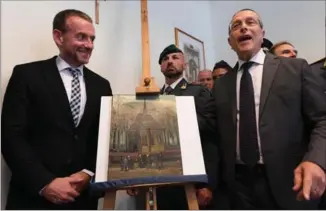  ?? CIRO FUSCO, THE ASSOCIATED PRESS ?? Director of Amsterdam’s Van Gogh Museum Axel Ruger, left, and Naples prosecutor Giovanni Colangelo stand next to the painting ‘Congregati­on leaving the Reformed Church of Nuenen,’ in Naples, Italy, Friday.