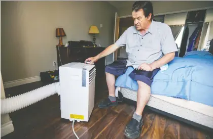  ?? JOHN MAHONEY ?? James Macleod, one of dozens of seniors to receive an air conditione­r this month thanks to a group of Good Samaritans, adjusts the settings Monday in the bedroom of his apartment in Dollard-des-ormeaux. “I will never forget these people,” he said. “I am so grateful.”