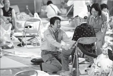  ?? MARTIN BUREAU / AGENCE FRANCE-PRESSE ?? Japan’s Prime Minister Shinzo Abe visits a shelter for people affected by the recent flooding in Mabi, Okayama prefecture,
on Wednesday.