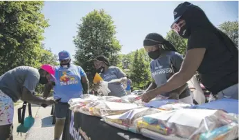  ?? ANTHONY VAZQUEZ/SUN-TIMES ?? Cherelle Bilal (left) helps a resident at the school-supplies event in Englewood.