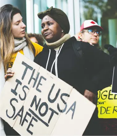  ?? NATHAN DENETTE / THE CANADIAN PRESS ?? Kikome Afisa, right, is comforted as she along with others protest Monday outside the Federal Court of Canada building in Toronto as a judge opened a hearing on the designatio­n of the U.S. as a safe third country for refugees.