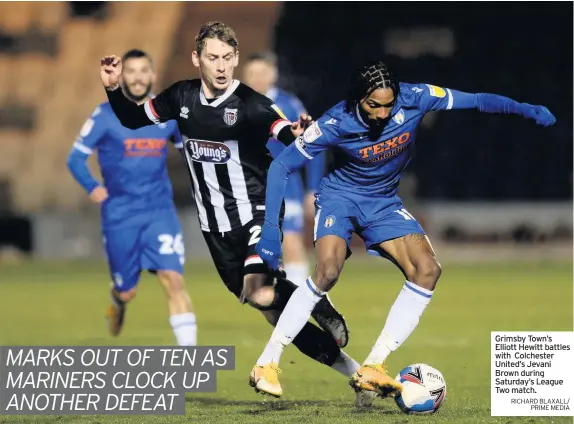  ?? RICHARD BLAXALL/
PRIME MEDIA ?? Grimsby Town’s Elliott Hewitt battles with Colchester United’s Jevani Brown during Saturday’s League Two match.