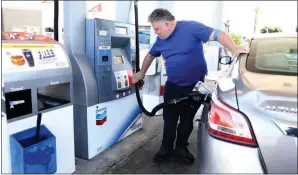  ?? PHOTO: GARY CORONADO/LOS ANGELES TIMES ?? Joseph Starr of Aliso Viejo pumps gas at the Chevron station in Orange in March, when gas prices were on the rise.