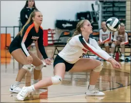  ?? Staff photo/David Pence ?? Minster’s Lilly Barhorst bumps the volleyball as Lindi Hemmelgarn readies behind her last week during the Wildcats’ match against St. Marys.