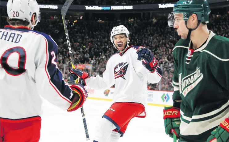  ?? — THE ASSOCIATED PRESS ?? Columbus Blue Jackets’ Brandon Saad and Seth Jones celebrate a goal as the Wild’s Nino Niederreit­er skates by during Saturday’s game in St. Paul, Minn.