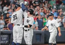  ?? JULIE JACOBSON/AP PHOTO ?? Aaron Judge (99) congratula­tes Clint Frazier as Brett Gardner, right, watches after Frazier hit a three-run home run during the fifth inning of the Yankees’ 6-1 win over the Tampa Bay Rays on Friday night in the Bronx. Judge and Gardner also homered.