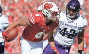  ?? MARK HOFFMAN, MILWAUKEE JOURNAL SENTINEL ?? Wisconsin wide receiver Danny Davis III picks up 32 yards on a reception while being pursued by Northweste­rn linebacker Paddy Fisher during their game Sept. 30.