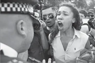  ?? DANIEL LEAL-OLIVAS / AGENCE FRANCE-PRESSE ?? A woman argues with a police officer as people gather in London on Wednesday to protest the British government’s poor response to last week’s deadly fire at Grenfell Tower. About 600 buildings in England could have been fitted with flammable external...