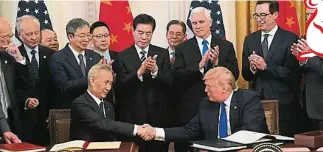  ??  ?? 特朗普与刘鹤签署中美­第一阶段贸易协议后，握手祝贺。（法新社照片）