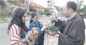  ??  ?? El hermano Valentín Pesente implora la bendición para las mascotas. Fue ayer frente a la capilla de San Leopoldo, en Asunción.