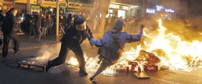  ?? Dpa-BILD: Gateau ?? Polizei und Teilnehmer geraten bei einem Feuer am Rande des Demonstrat­ionszugs linker und linksradik­aler Gruppen in Berlin aneinander