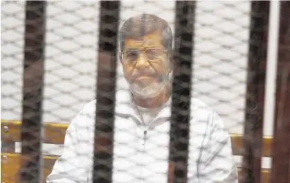  ?? Photo / AP ?? Egypt's ousted Islamist President Mohammed Morsi sits in a defendant cage in the Police Academy courthouse in Cairo in 2014.