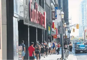  ?? RENÉ JOHNSTON TORONTO STAR ?? Patrons line up to get into Goodlife Fitness on Yonge Street.