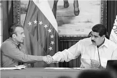  ??  ?? Maduro (right) and El Aissami shake hands during a meeting with governors in Caracas, Venezuela. — Reuters photo
