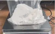  ??  ?? Police weigh white powder believed to be cocaine.