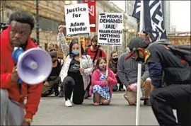  ?? Shafkat Anowar Associated Press ?? PROTESTERS KNEEL in downtown Chicago on Tuesday, two weeks after the police killing of Adam Toledo, 13. Video of the shooting was released Thursday.