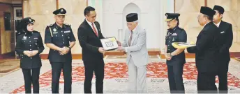  ?? — Penerangan photo ?? Taib presents a memento to Matthew (third left) during the courtesy call.