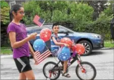  ?? ANNE NEBORAK – DIGITAL FIRST MEDIA ?? Harman Pabla 6, rides his decorated bike as his sister Maneet, 12, walks along waving the flag.