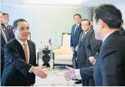  ?? EPA ?? Lao Prime Minister Thongsing Thammavong shakes hands with Japan’s Foreign Minister Fumio Kishida prior to their meeting in Tokyo yesterday. The Lao prime minister arrived in Japan for a fourday long official visit.