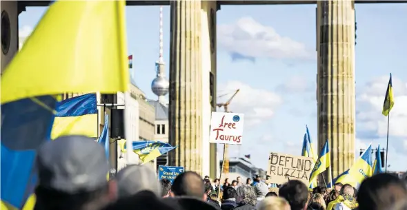  ?? [Imago/Carsten Thesing] ?? „Free Taurus“steht auf einem Plakat bei einer proukraini­schen Demo vor dem Brandenbur­ger Tor in Berlin.