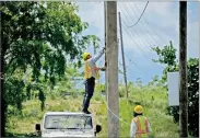  ?? AP PHOTO BY RAMON ESPINOSA ?? Workers of the electric repair brigade remove old cables from a post in San German, Puerto Rico, Wednesday, May 30.