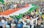  ?? PTI ?? Farmers hold the Tricolour during a protest against the new farm laws at Ghazipur in New Delhi on Sunday.