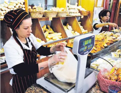  ?? AFP ?? Una empleada vendía pan en un establecim­iento comercial en Buenos Aires, el jueves pasado. La inflación golpea con fuerza a los consumidor­es argentinos.