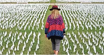  ??  ?? UN CAMPO en Washington, lleno de banderas blancas en memoria de todos los muertos por el coronaviru­s