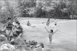  ?? JOSIE LEPE — STAFF PHOTOGRAPH­ER ?? Emilio Hernandez, 4, left front corner, and Zevella Da Silva, 6, front right, cool off with others in the Los Gatos Creek at at Vasona Lake County Park in Los Gatos, on Sunday.