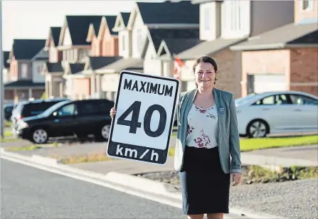  ?? JESSICA NYZNIK EXAMINER ?? Mayoral candidate Diane Therrien shows off a speed limit sign on Settlers Ridge in the city’s north end Wednesday. Therrien’s safe streets plan would lower the speed limit from 50 km/h to 40 km/h in residentia­l areas and to 30 km/h in safety zones.