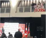  ?? ROBERT BENZIE/TORONTO STAR ?? Protesters unfurl a spray-painted banner reading “We Are The Future of Education” from above the dais.