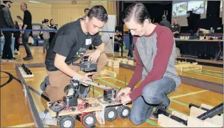  ?? SAM MCNEISH/THE TELEGRAM ?? Ascension Collegiate students Colby Pryor (Grade 11) and Brandon Dixon (Grade 12) prepare their robots for competitio­n at the Skills Canada Newfoundla­nd and Labrador’s Annual Skilled Career Day at the College of the North Atlantic’s Prince Philip Drive campus on Friday. The students’ robotics project was aimed at the oil and gas industry and how the fuel will be transferre­d from the source to the refinery. The pair won a silver medal in the robotics – secondary competitio­n.