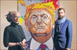 ?? REUTERS ?? Artists Daria Marchenko and Daniel D Green pose in front of their portrait of US President Donald Trump made of coins and casino tokens in a classroom in New York on Wednesday.