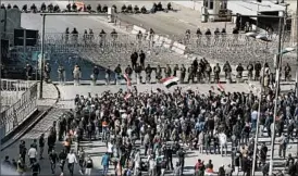  ?? KARIM KADIM/AP ?? Iraqi police close a bridge leading to the fortified Green Zone in Baghdad on Saturday.