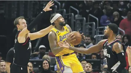  ?? PATRICK BEVERLEY Luis Sinco Los Angeles Times ?? of the Lakers tries to squeeze between Clippers defenders Luke Kennard, left, and Paul George in first half.