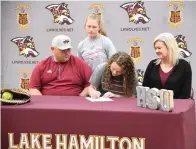  ?? The Sentinel-Record/Tanner Netwon ?? ■ Lake Hamilton senior Kaylin Kauffman signs to play at Henderson State, while Reid, Kacie and Leslie Kauffman look on at Lake Hamilton’s Wolf Arena Wednesday.