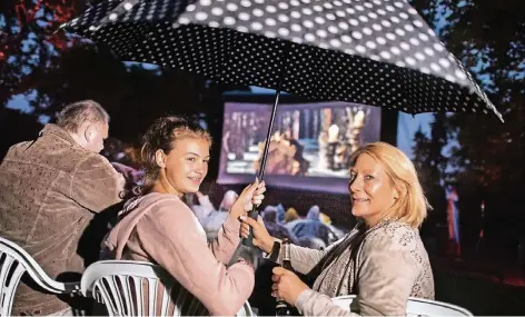  ?? RP-FOTO: RALPH MATZERATH ?? Emily (m.), Claudia (r.) und Dirk Kilian harrten im Regen aus, als vor „Willkommen bei den Hartmanns“ein Trailer auf der Leinwand zu sehen war.