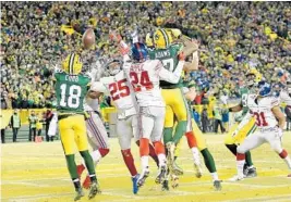  ?? STACY REVERE/GETTY IMAGES ?? Green Bay’s Randall Cobb (18) catches a touchdown pass at the end of the second quarter on a Hail Mary pass from Aaron Rodgers.