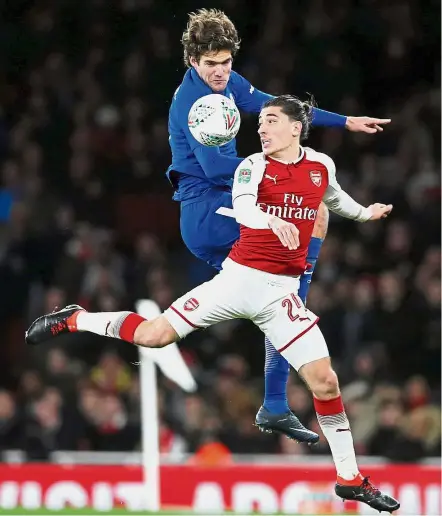  ?? — Reuters ?? Eyes on the ball: Arsenal’s Hector Bellerin (front) in action against Chelsea’s Marcos Alonso during the second leg of the League Cup semi-finals at the Emirates on Wednesday.