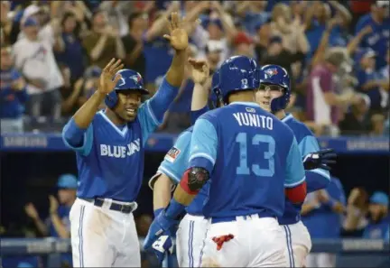  ?? JON BLACKER — THE CANADIAN PRESS VIA AP ?? The Toronto Blue Jays’ Curtis Granderson, left to right, Lourdes Gurriel Jr. and Danny Jansen celebrate after teammate Aledmys Diaz’s three-run double against the Philadelph­ia Phillies during the eighth inning Saturday in Toronto.