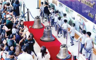  ?? (Ali Vicoy) ?? INSTANT HIT – Visitors, young and old, pack the Philippine Air Force Museum at Villamor Air Base, Wednesday, to get a glimpse of the Balangiga bells which were returned, after 117 years, by the United States government last Tuesday.