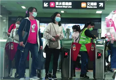  ?? AP ?? Un grupo de viajeros con mascarilla­s abandona la estación de Taipei