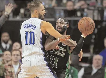  ?? STAFF PHOTO BY STUART CAHILL ?? TOUGH TO STOP: Kyrie Irving looks to pass despite being closely guarded by the Magic’s Evan Fournier last night at the Garden. Irving’s 30 points sparked the Celtics to a big lead en route to an eventual 118-103 victory.