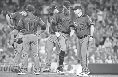  ?? JOHN MINCHILLO/AP ?? Diamondbac­ks reliever Archie Bradley (center) is relieved by manager Torey Lovullo in the eighth inning of Saturday night’s game against the Reds in Cincinnati.