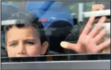  ??  ?? A young refugee looks out of a bus at the railway station in Freilassin­g, Germany, yesterday.